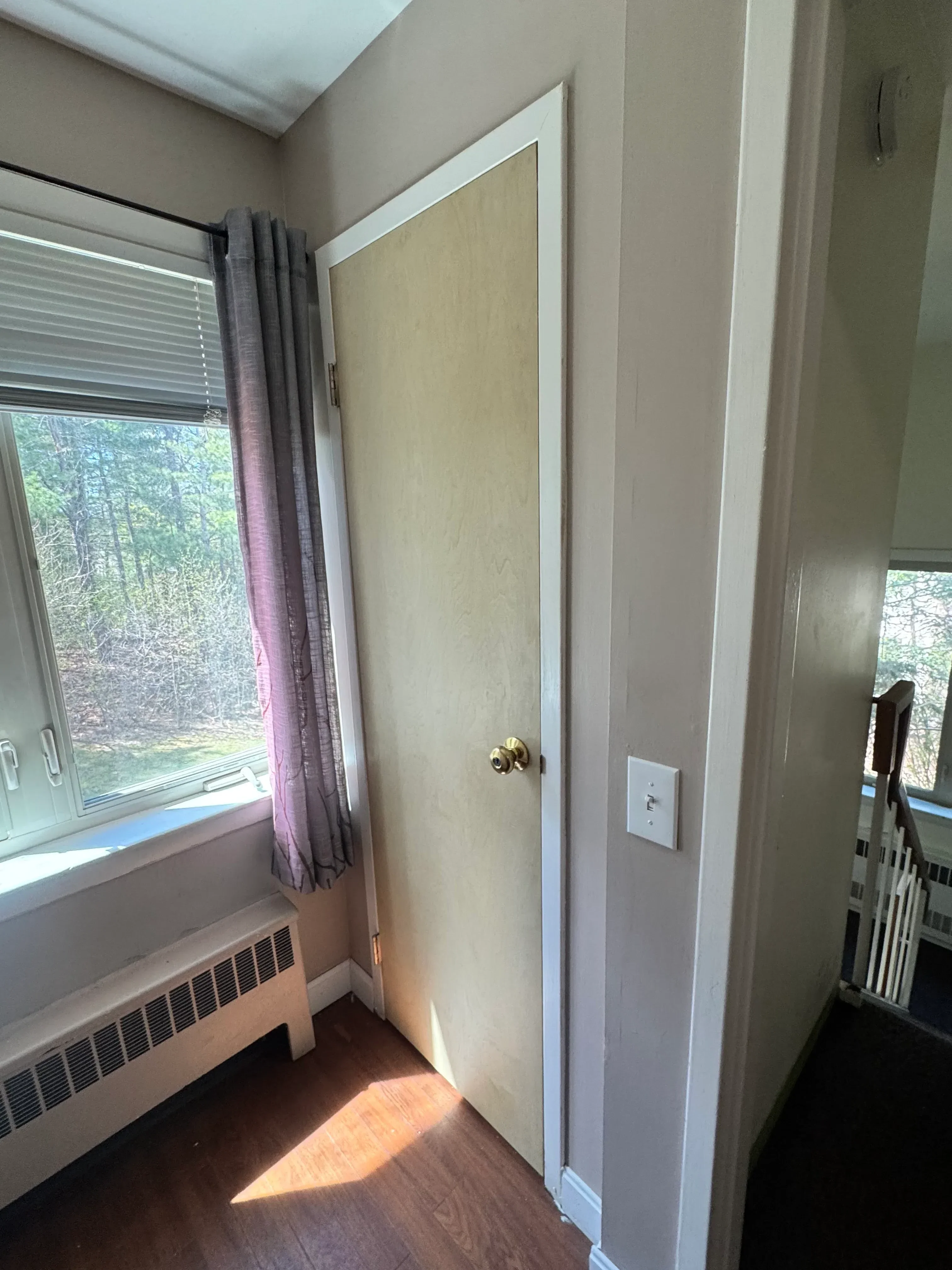 Painted drywall ceiling with recessed lighting and white trim framing around bedroom window installation
