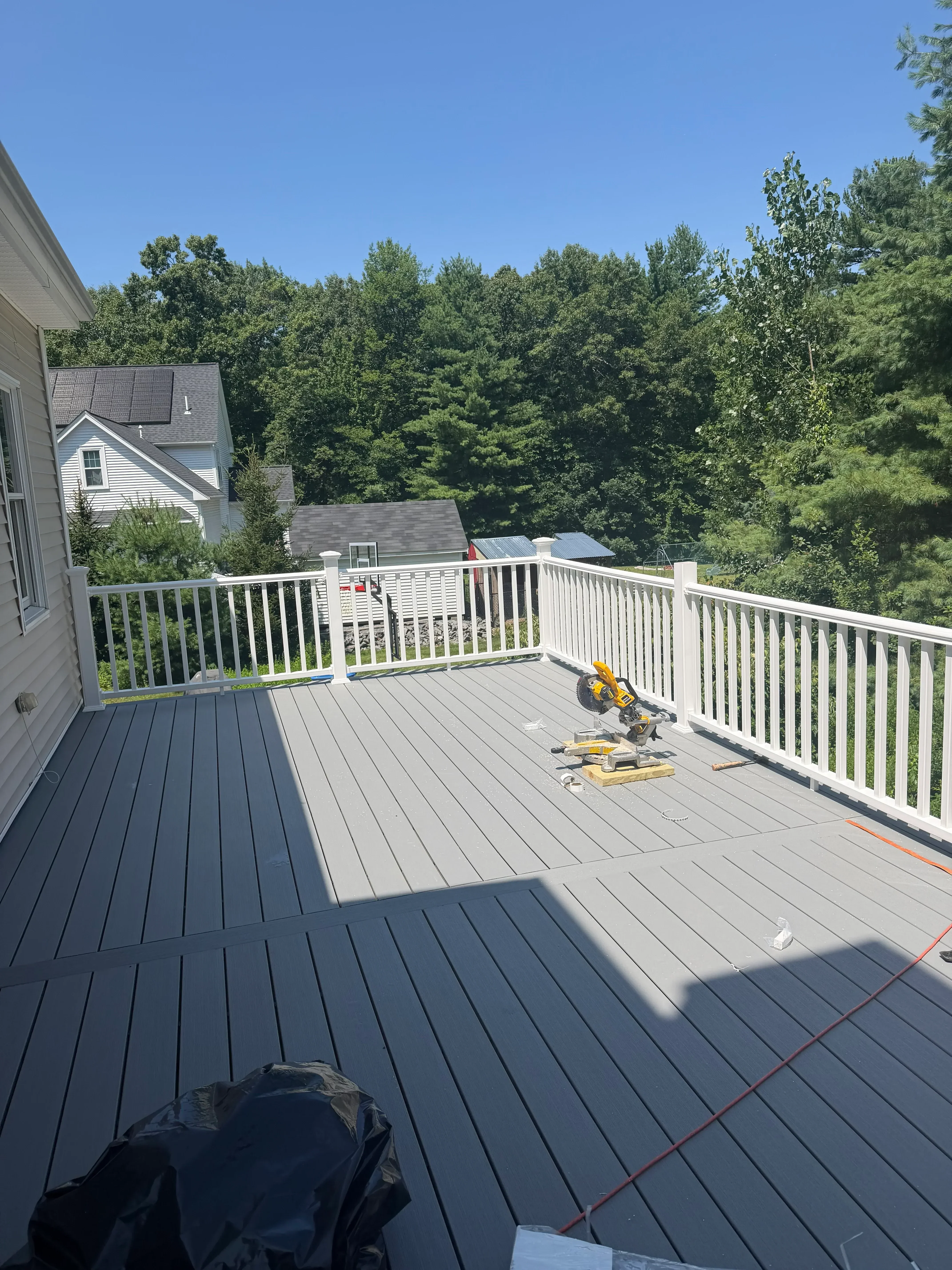 Composite deck with horizontal railings and built-in planter boxes alongside modern home exterior