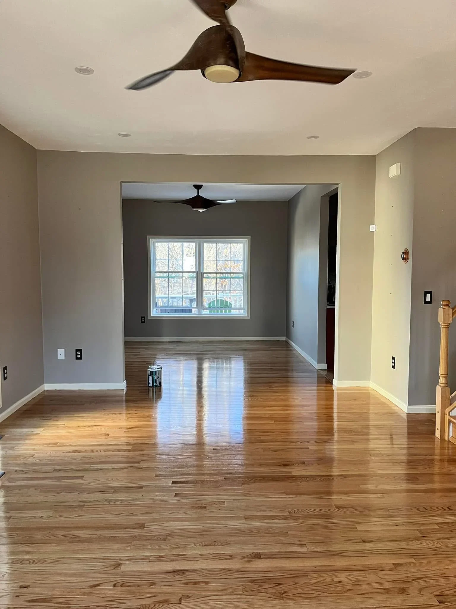 Hardwood flooring installation in open room with ceiling fan and recessed lighting