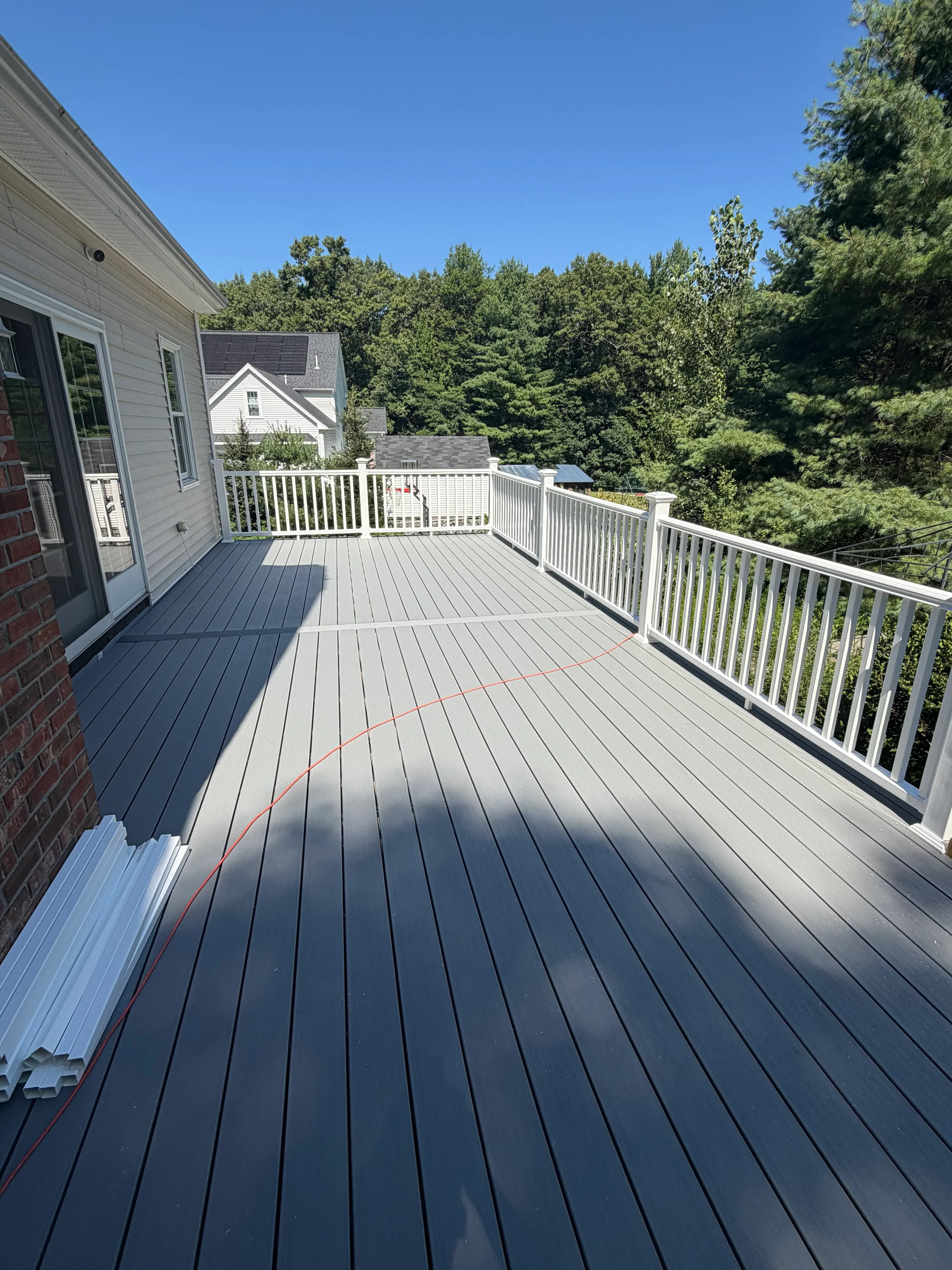 Horizontal metal siding installation with louvered pergola and white trim details